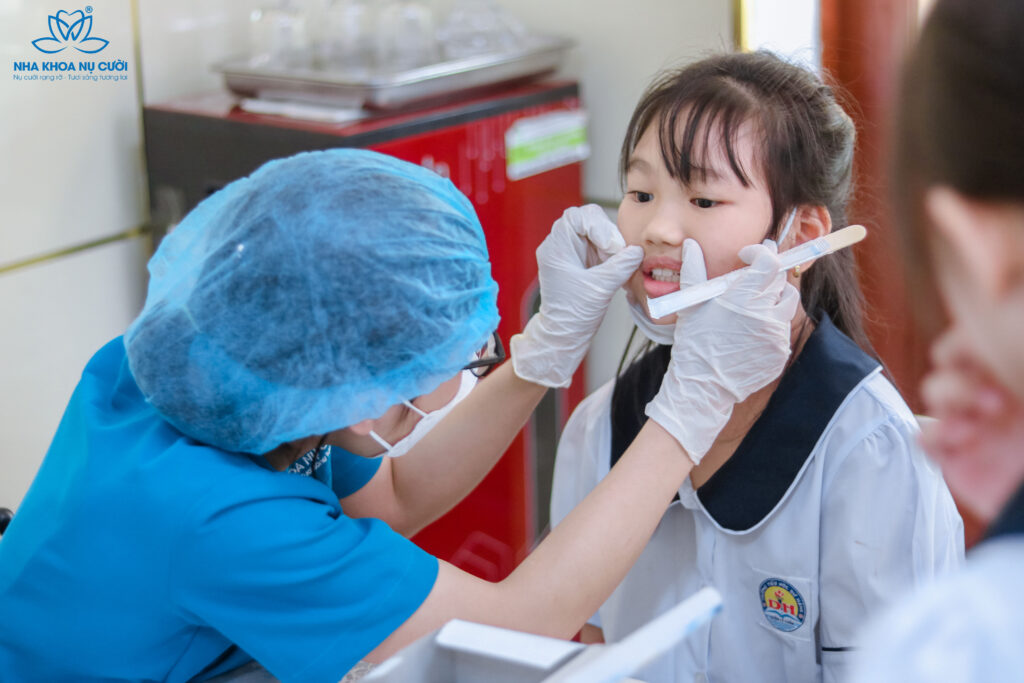 (Các y bác sĩ trực tiếp thăm khám, tư vấn miễn phí răng miệng cho học sinh)